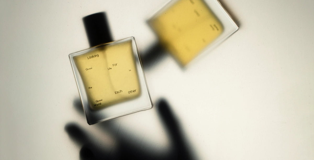 Flatlay of Looking for Each Other’s perfume bottles casting soft shadows—showcasing the warm golden hues of plant-based scent.