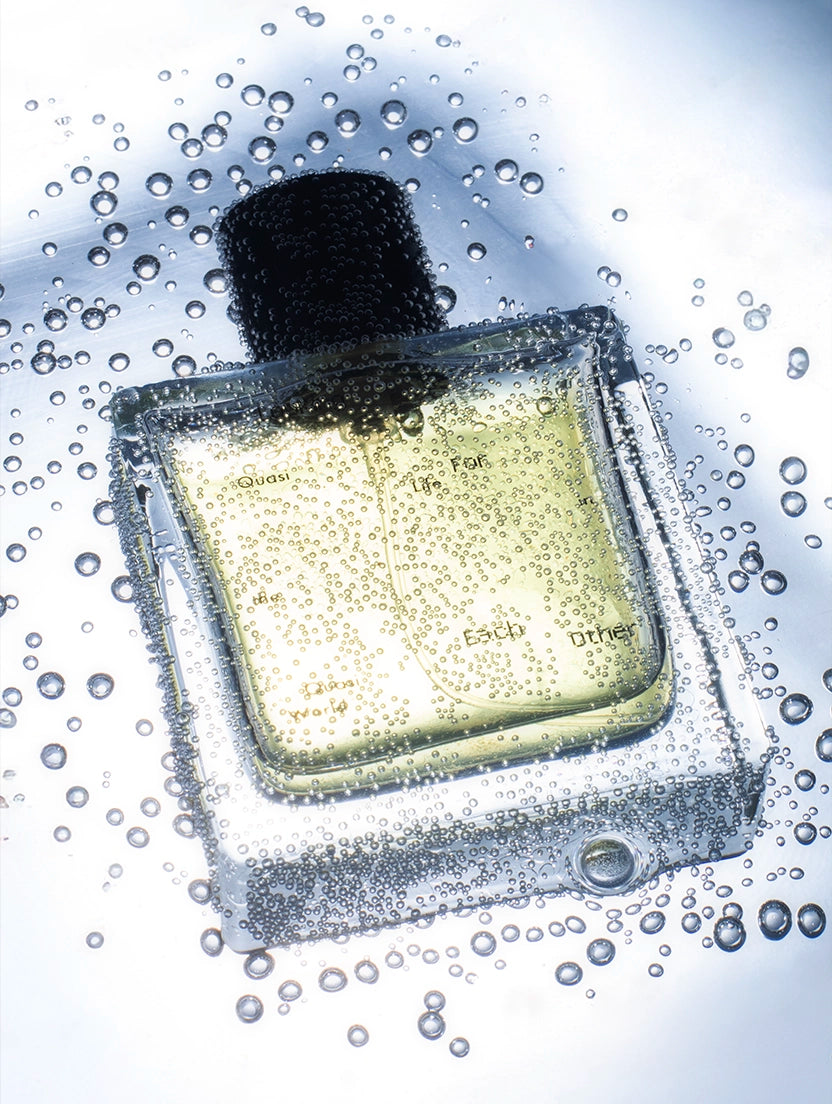 Close-up of a Quasi Life in the Quasi World bottle by Looking for Each Other, covered in water droplets—highlighting the purity and minimalism of 100% botanical fragrance.